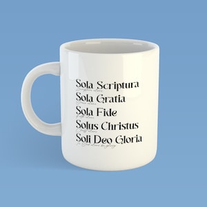 Puede incluir: Taza de cer&aacute;mica blanca con texto negro que dice "Sola Scriptura Escritura sola", "Sola Gratia Gracia sola", "Sola Fide Fe sola", "Solus Christus Cristo solo", y "Soli Deo Gloria A Dios solo la gloria".