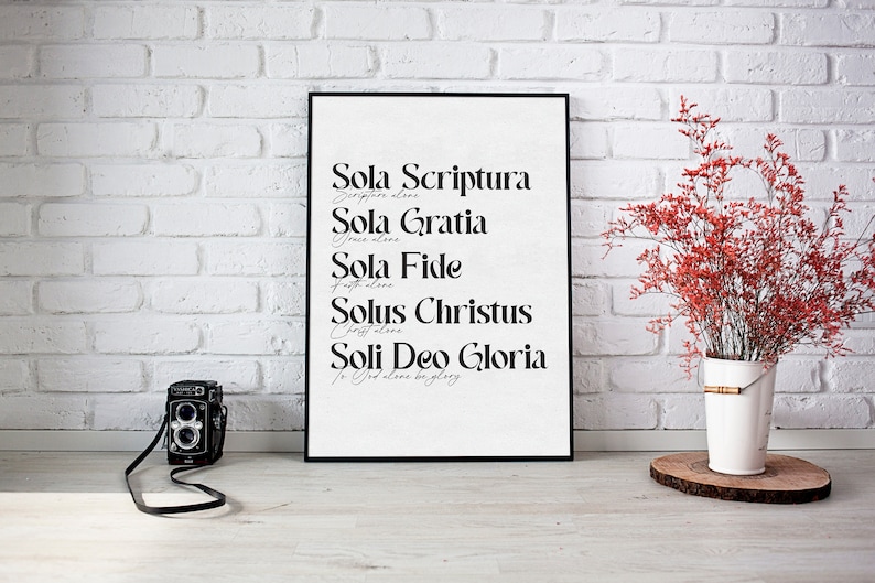 Puede incluir: Impresi&oacute;n en blanco y negro con el texto "Sola Scriptura, Escritura sola", "Sola Gratia, Gracia sola", "Sola Fide, Fe sola", "Solus Christus, Cristo solo" y "Soli Deo Gloria, A Dios sola la gloria". La impresi&oacute;n est&aacute; enmarcada en un marco negro y est&aacute; colgada en una pared de ladrillo blanco.