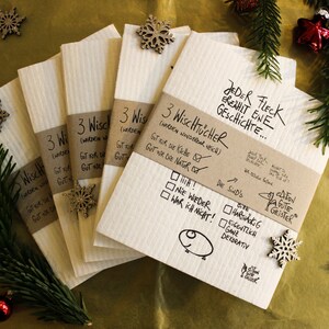 May include: A set of six brown and white kitchen cloths with the text "3 WiscHTUCHER (werden wunderbar neu)" and "JEDER FLECK EREAHIT ENE GESCHICHTE..." printed on them. The cloths are decorated with snowflakes and a small drawing of a pig.
