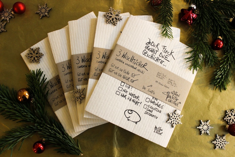 May include: A set of six brown and white kitchen cloths with the text "3 WiscHTUCHER (werden wunderbar neu)" and "JEDER FLECK EREAHIT ENE GESCHICHTE..." printed on them. The cloths are decorated with snowflakes and a small drawing of a pig.