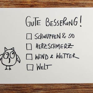 Könnte beinhalten: Eine weiße Karte mit dem deutschen Satz "Gute Besserung!" und einer Checkliste mit vier Punkten. Auf der linken Seite ist eine Cartoon-Eule gezeichnet. Die Karte liegt auf einer Holzoberfläche.