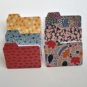 May include: Set of six colourful patterned file folders with different floral and leaf designs. The folders are made of sturdy cardstock and are perfect for organising documents, papers, and other items.