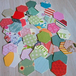 May include: A collection of colorful hexagon-shaped paper pieces with various patterns, including floral, geometric, and polka dots. The paper pieces are arranged in a random pattern, creating a visually appealing and textured design.