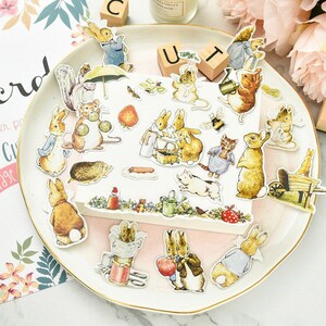May include: A set of 20 colorful stickers featuring illustrations of Peter Rabbit and other characters from Beatrix Potter's stories. The stickers are perfect for adding a touch of whimsy to journals, planners, and other craft projects.