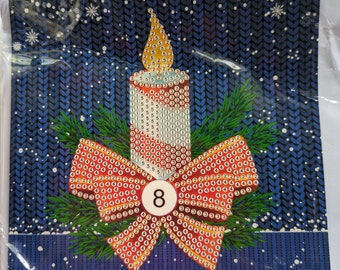 May include: A red and white striped candle with a yellow flame sits on a green wreath with a red bow. The bow has a white circle with the number 8 in the center. The background is a blue knitted pattern with white snowflakes. The text "Merry Christmas!" is printed at the bottom of the image.