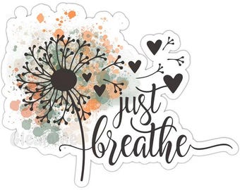May include: A die-cut sticker featuring a black dandelion silhouette with seeds blowing away as small hearts. The background has a watercolor-style splash of orange, green, and tan tones. The text "just breathe" is written in a black cursive script.
