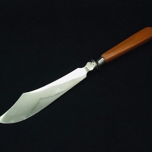 May include: A silver butter knife with a brown plastic handle.