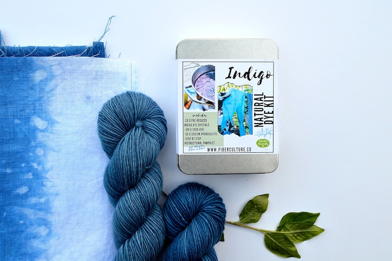 May include: A tin of natural indigo dye kit with a blue and white label that says "Indigo Natural Dye Kit" and includes a picture of a pair of blue jeans. The kit includes 20 grams of indigo powder, soda ash, and a step-by-step instruction pamphlet. The kit is made by Fiberculture Co.