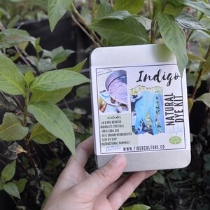 May include: A metal tin with a label that says "Indigo Natural Dye Kit" and includes a list of ingredients: 20 g Pre-Reduced Indigo Dye Crystals, 100 g Soda Ash, 50 g Sodium Hydrosulphite, 1 Step by Step Instructional Pamphlet, www.fiberculture.co. The tin is in the hand of a person.