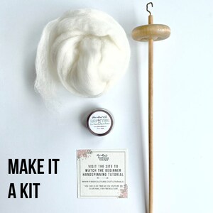 May include: A hand spinning kit with a wooden spindle, a small tin of fiber prep, and a ball of white wool. The card reads "Make it a kit" and "Visit the site to watch the beginner handspinning tutorial www.fiberculture.co/tutorials".