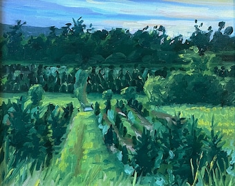 May include: A framed painting depicting a landscape with a field of green trees and bushes under a cloudy sky.