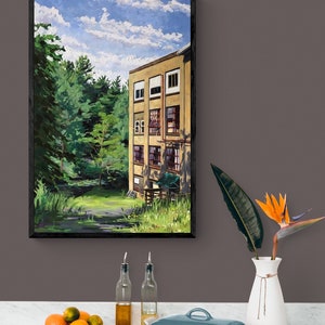 May include: A framed painting of a yellow building with windows, set against a backdrop of green trees and a blue sky with white clouds. The building is surrounded by a grassy area.