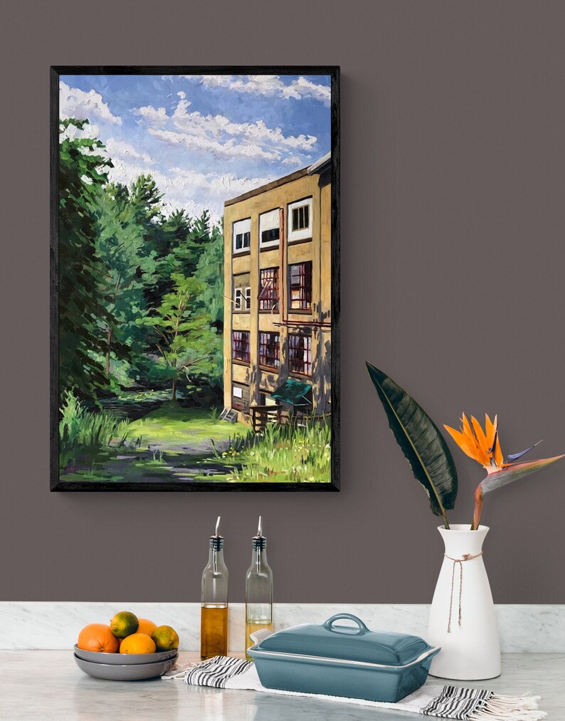 May include: A framed painting of a yellow building with windows, set against a backdrop of green trees and a blue sky with white clouds. The building is surrounded by a grassy area.