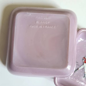 K&ouml;nnte beinhalten: Eine quadratische, violette Plastikbox mit abgerundeten Kanten. Die Box tr&auml;gt ein Etikett mit der Aufschrift "Made in France" und "Mastur Blangy".