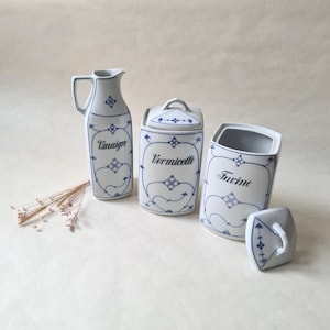 Könnte beinhalten: Ein Set aus drei vintage Keramik-Küchenbehältern mit blauen und weißen Blumenmustern. Die Behälter sind mit "Vinaign", "Vermicelle" und "Farine" beschriftet.
