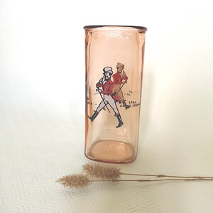 Peut inclure: Un verre en verre rose avec une image imprim&eacute;e de deux hommes en v&ecirc;tements rouge et blanc marchant avec des b&acirc;tons de marche. Le texte "Still Going Strong" est imprim&eacute; sur le verre.