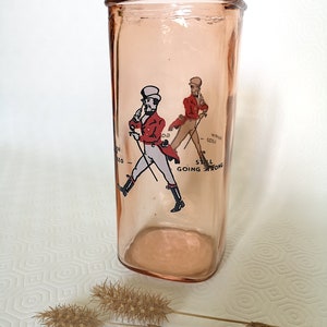 Peut inclure: Un pot en verre rose avec une image imprim&eacute;e d'un homme en veste rouge et pantalon blanc marchant avec une canne. Le texte "Still Going Strong" est imprim&eacute; sous l'image.