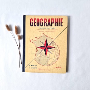 Peut inclure: Un manuel de géographie français vintage à couverture beige, illustré d'une rose des vents noire et rouge, d'une carte de France et du texte GEOGRAPHIE CLASSE DE FIN D'ETUDES CERTIFICAT D'ETUDES PRIMAIRES CENTRES D'APPRENTISSAGE A.MERLIER G.LEROUX A.HATIER.