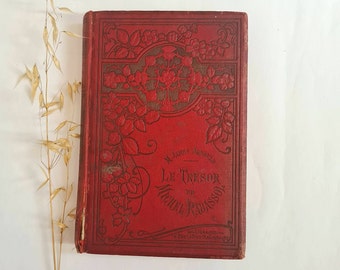 May include: A red hardcover book with a floral design on the cover. The title of the book is "Le Tresor de Michel Rabassol" by M. Jean's Agrippa. The book is published by "Librairie de l'Education Nationale".