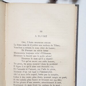 May include: A page from a book with the title "A Elvire" and text in French. The text is a poem about a woman named Elvire. The page is yellowed with age and has a worn, vintage look.