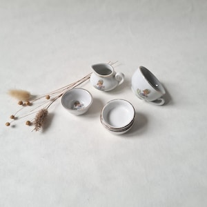 Peut inclure: Un service à thé en porcelaine blanche avec un motif floral. L'ensemble comprend un pot à crème, une tasse à thé et une soucoupe.