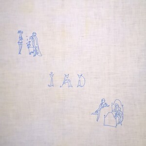 Puede incluir: Una tela de lino blanco con bordado azul de dos figuras de pie y una tercera sentada. La palabra "IAD" est&aacute; bordada en azul debajo de las figuras. La parte inferior de la tela presenta una imagen bordada azul de dos figuras en una cama.