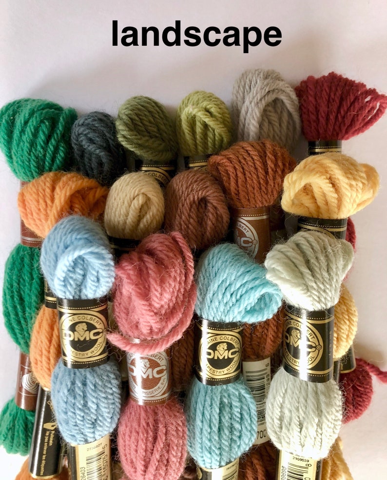 May include: A collection of skeins of embroidery floss in various shades of green, brown, orange, yellow, pink, blue, and gray. The skeins are wrapped in paper with the DMC logo and the text "The Colbert" printed on them.