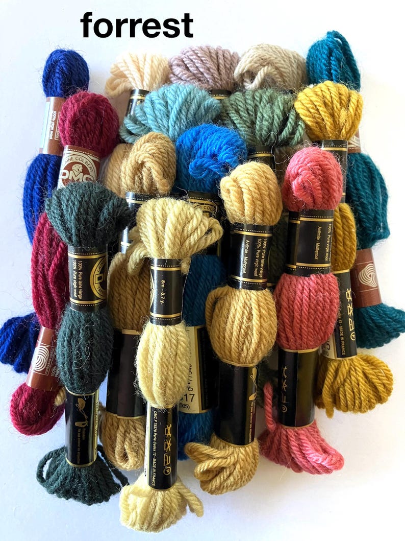 May include: A collection of DMC embroidery floss spools in various colors, including red, blue, green, yellow, and brown. The spools are labeled with the DMC color number and the text "100% Pure laine vierge" and "100% Pure virgin wool".