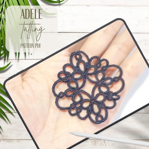 Puede incluir: Un tapete de tatting azul marino con un diseño floral, sostenido en una mano. La imagen está en una tableta con el texto "ADELE Tatting PATTERN PDF" en la esquina superior izquierda. El fondo es una superficie de madera blanca.