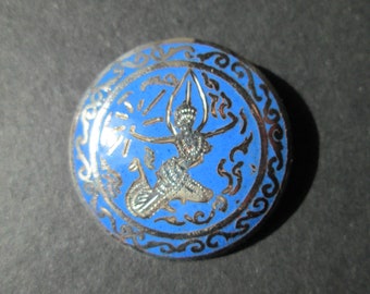 May include: A round, blue and silver pendant with a detailed design of a mythical creature. The creature is depicted in a silver color against a blue background. The pendant is surrounded by a silver border with a decorative pattern.