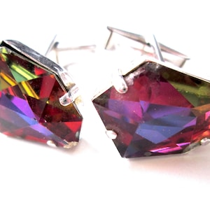 May include: A pair of silver cufflinks with faceted, multi-coloured glass stones. The stones are a mix of red, purple, green, and yellow.