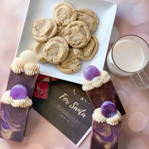 May include: Three bars of purple and brown swirl soap with a white swirl on top and a purple swirl on top. Each bar has a small purple circle on top. A note says "For Santa Don't forget to wash your hands before you leave. Thank you."