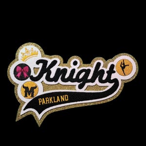 May include: Gold glitter patch with black lettering that says "Knight" and "Parkland". The patch also features a crown, a pink bow, a bull's head, and a dancer.