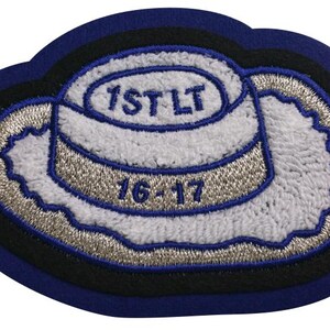 May include: A blue and silver embroidered patch with the text "1ST LT" and "16-17".