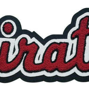 May include: A black and white embroidered patch with the word "Pirates" in red script. The lettering has a textured, stitched appearance, with a white outline and a black border. The patch is designed for apparel.