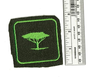 May include: Green embroidered patch with a green tree on a dark green background. The patch is approximately 2 inches square.