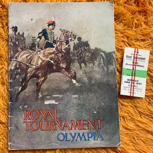 Op de afbeelding: Vintage Royal Tournament Olympia-programma met een gedetailleerde illustratie van ruiters te paard. Er is ook een groen en wit ticket aanwezig, gedateerd 16 juni 1947.