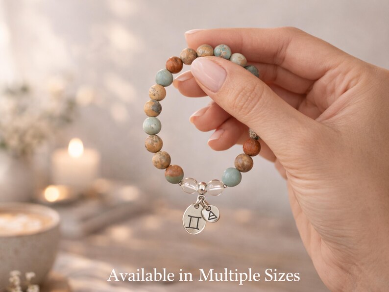 Gemini bracelet for women shown in hand with stretch fit and multiple size options, Aqua Terra Jasper and crystal quartz zodiac bracelet with Gemini charms