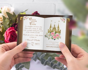 Może przedstawiać: Zaproszenie na baby shower w kształcie książki z złotym zamkiem i kwiatowym wzorem. Zaproszenie zawiera napis "Dawno, dawno temu" oraz imiona Alexis & Martin, datę soboty, 5 lutego i godzinę 17:00.
