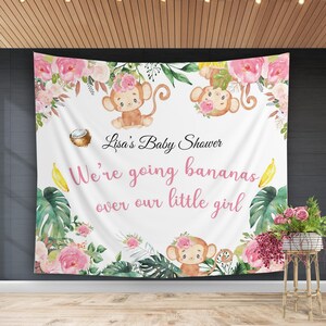 May include: A white baby shower backdrop with pink flowers, green leaves, and monkeys. The text reads "Lisa's Baby Shower We're going bananas over our little girl".
