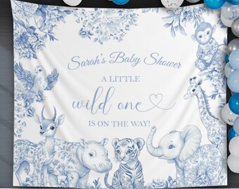 May include: A white baby shower backdrop with blue floral and animal illustrations. The text "Sarah's Baby Shower, A Little Wild One Is On The Way!" is written in blue script. Balloons in shades of blue and white are at the top.