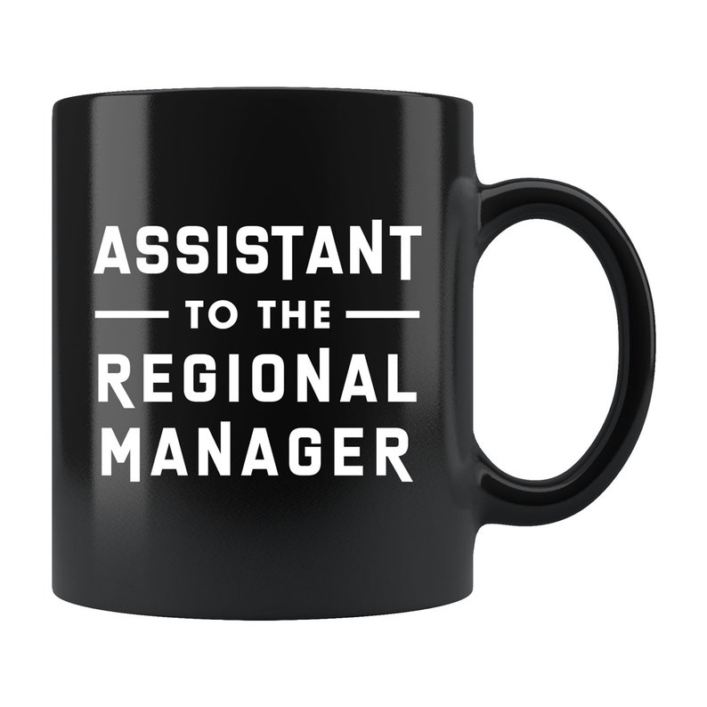 May include: Black ceramic coffee mug with white text that reads "Assistant to the Regional Manager".