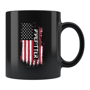 May include: Black ceramic coffee mug with a distressed American flag design and the text "PIPEFITTER" printed vertically on the right side of the flag.