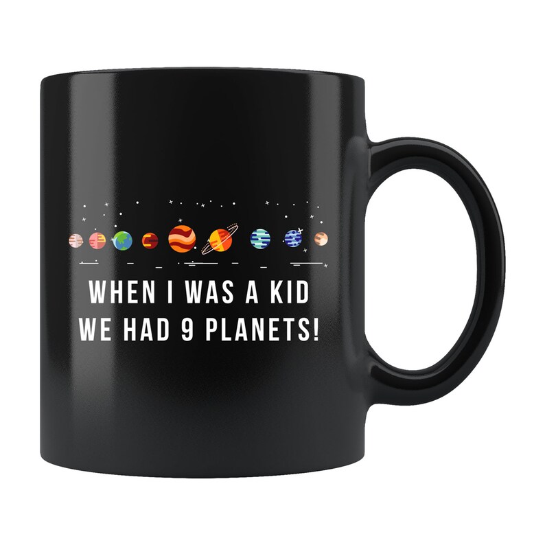 May include: Black coffee mug with a white graphic of the solar system and the text "When I was a kid we had 9 planets!"