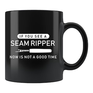 May include: Black ceramic coffee mug with white text that reads "If you see a seam ripper now is not a good time".