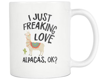 May include: White ceramic coffee mug with a black and white graphic of a llama wearing a colorful saddle and the text "I just freaking love alpacas, ok?"