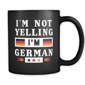 May include: Black coffee mug with white text that reads "I'm not yelling I'm German" with two German flags and three gold stars.