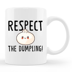 May include: White ceramic mug featuring a black graphic that reads "Respect the Dumpling!" and a cartoon dumpling with a smiling face.