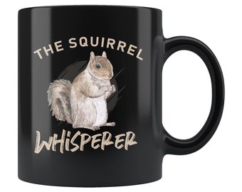 May include: Black coffee mug with a white squirrel illustration and the text "The Squirrel Whisperer".