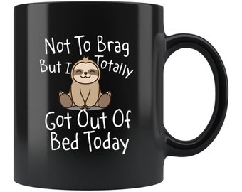 May include: Black coffee mug with a white graphic of a sloth and the text "Not To Brag But I Totally Got Out Of Bed Today".